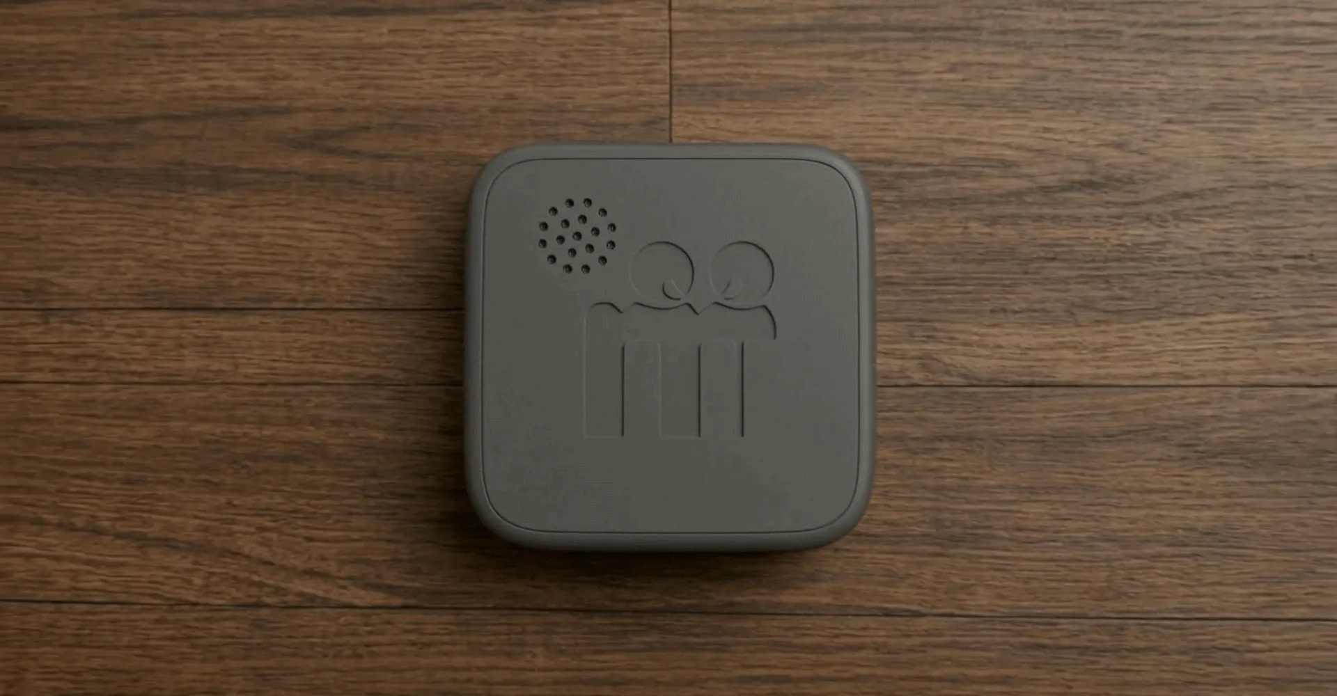 The Cookie resting face-up on a wooden table, its lid marked with the Modem figures.